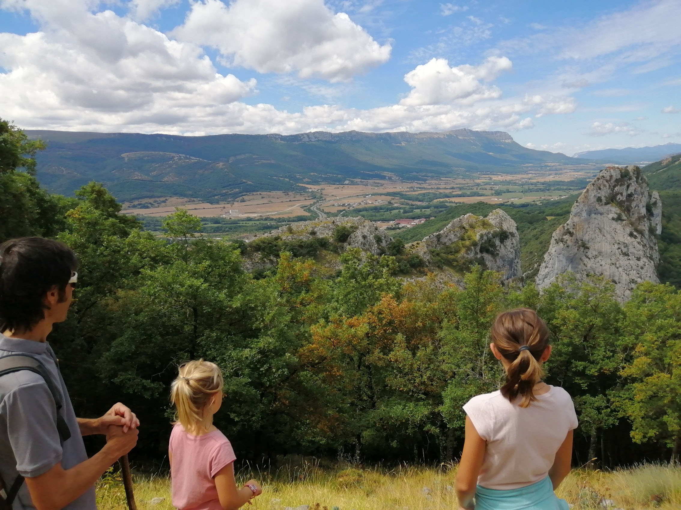 Dos niñas y un adulto contemplando las vistas hacia la Sakana